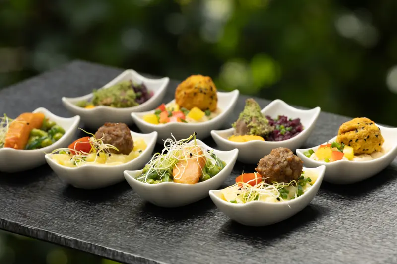 Fingerfood in Porzellan-Schälchen auf einer Schieferplatte